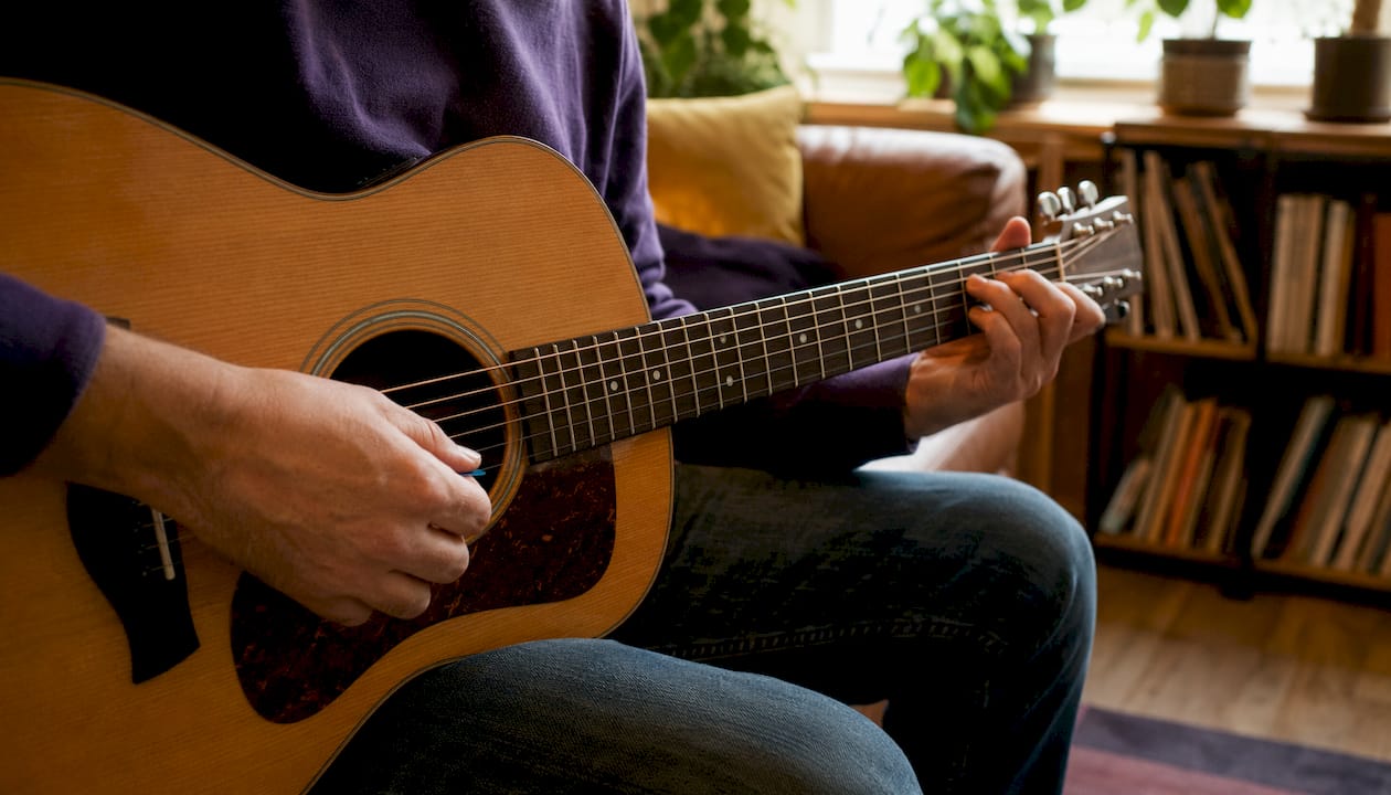 Close-up of hands holding guitar and pick properly