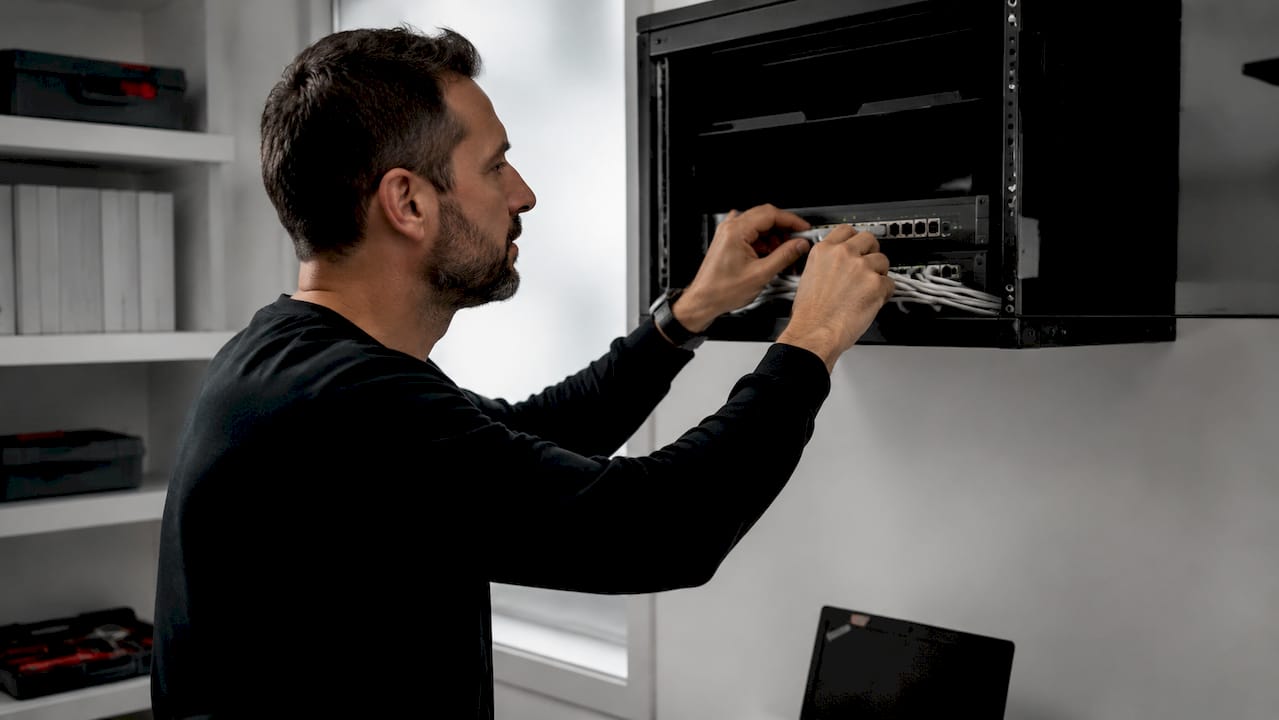 Technician connecting network hardware in server room