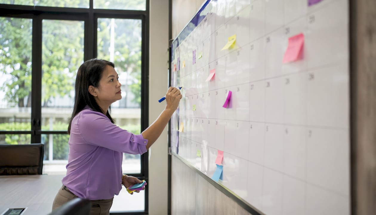 Hands marking calendar for HMO negotiation planning