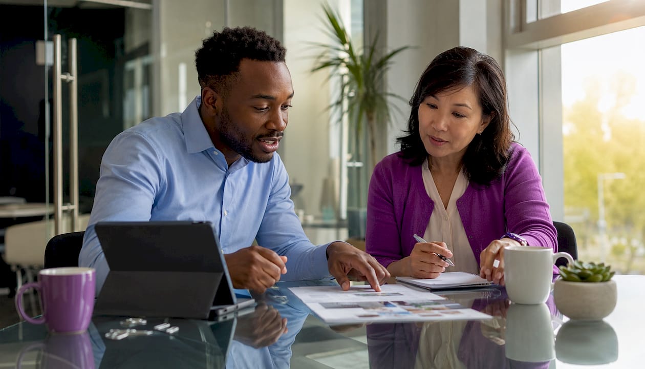 Two colleagues discussing accident insurance options in office