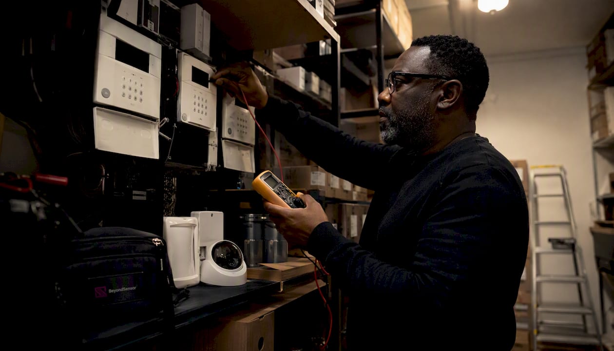Engineer inspecting smart sensor hardware in server room