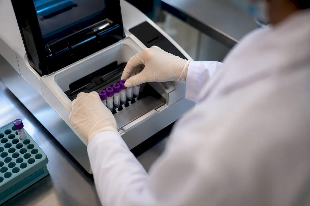Technician loading tubes into diagnostic analyzer