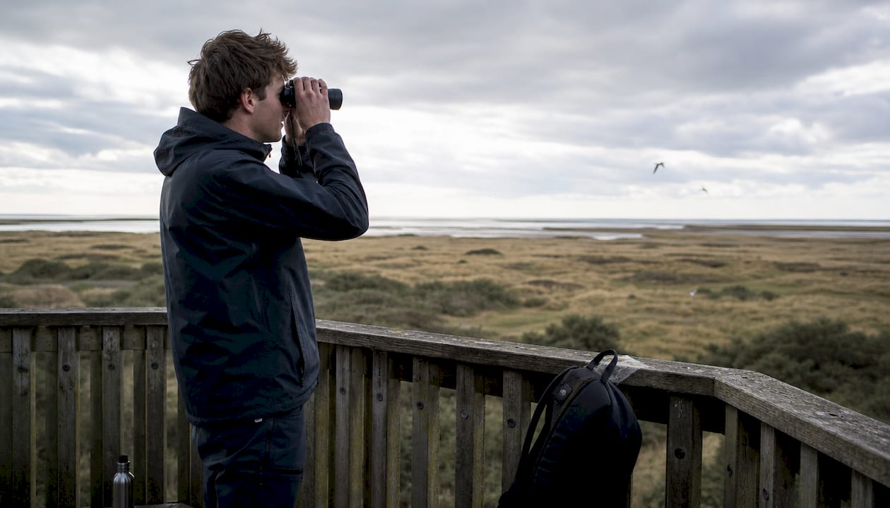 Een toerist geniet van de natuur op Ameland