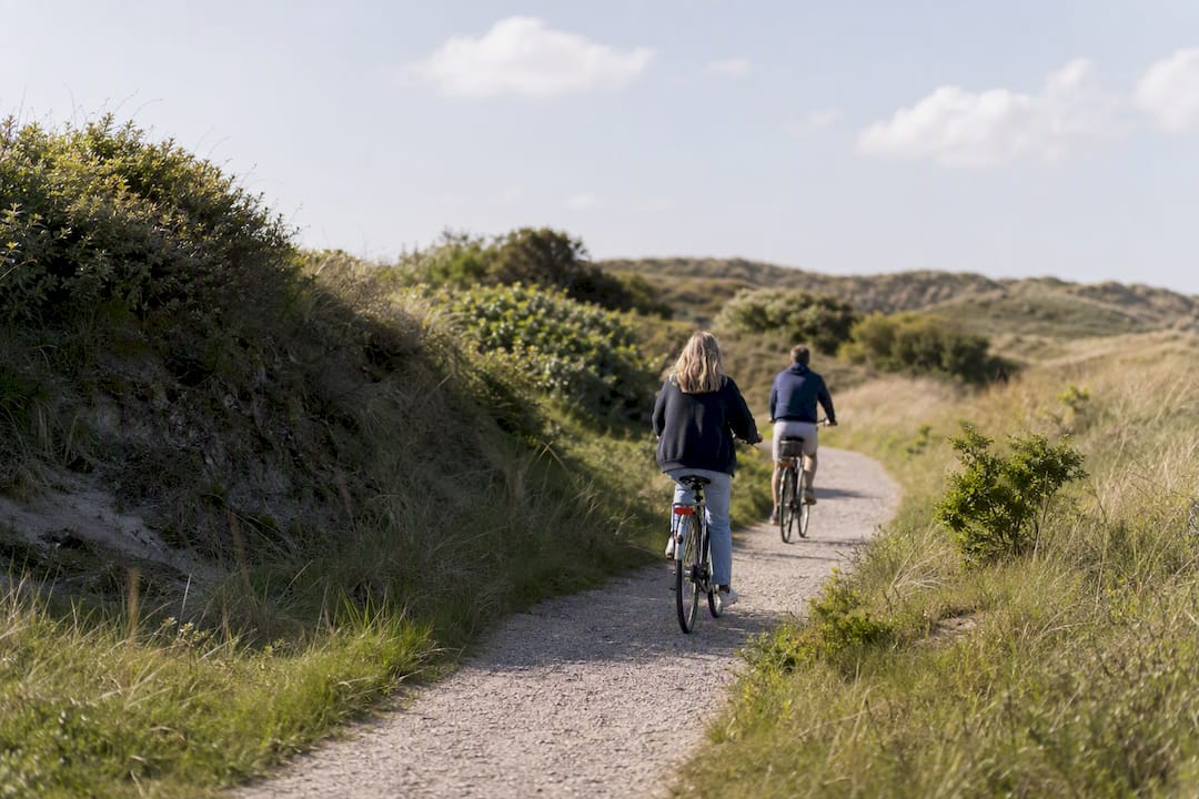Twee fietsers die achter elkaar op een smal pad rijden