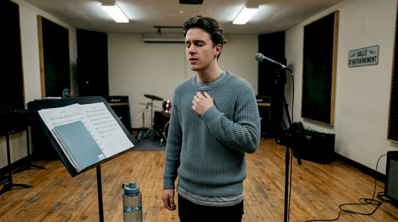 Chanteur concentré sur la justesse de sa voix lors d’une session en studio