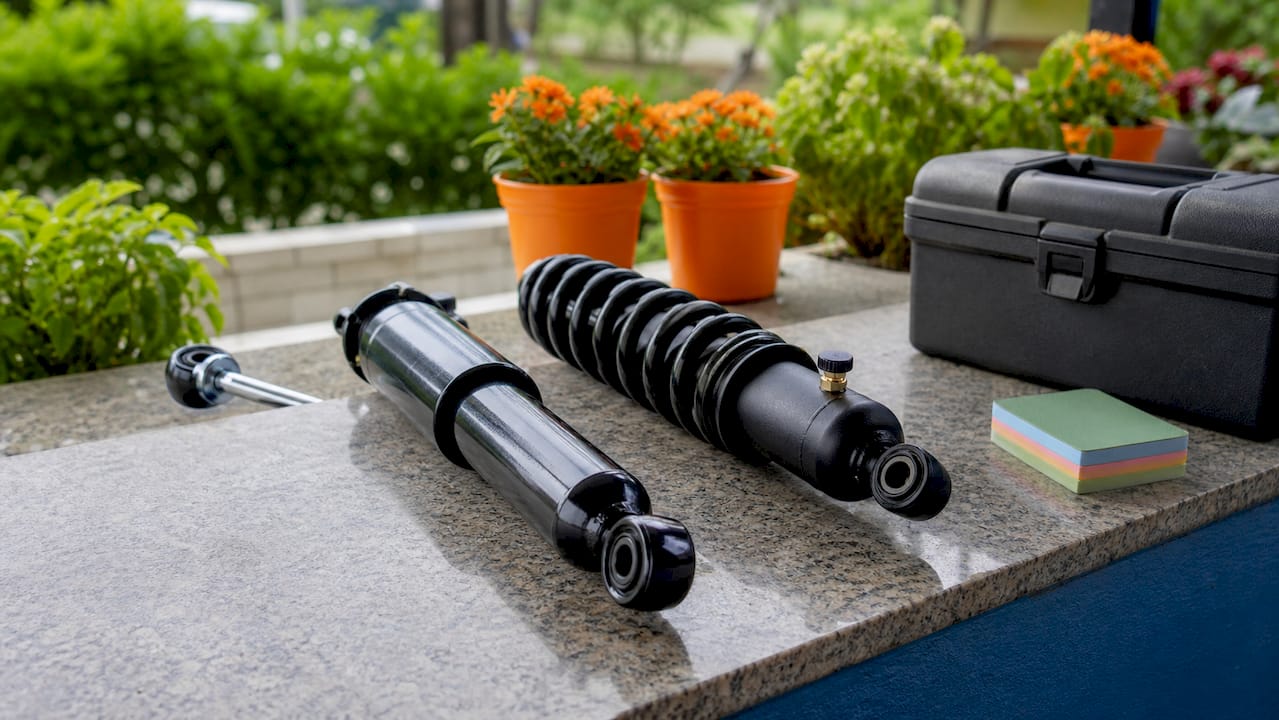 Close-up of oil and gas-charged golf cart shocks on workbench