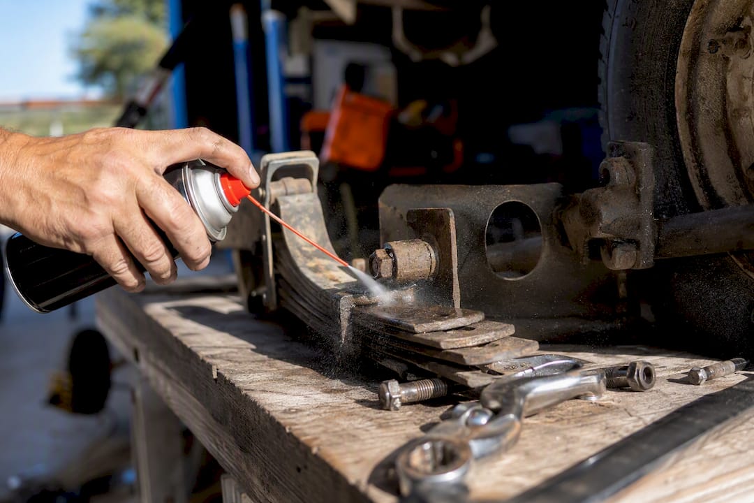 Hand spraying penetrating oil onto golf cart trilobe screw