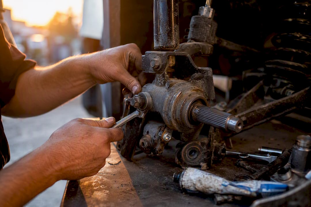 Hands turning golf cart spindle pivot