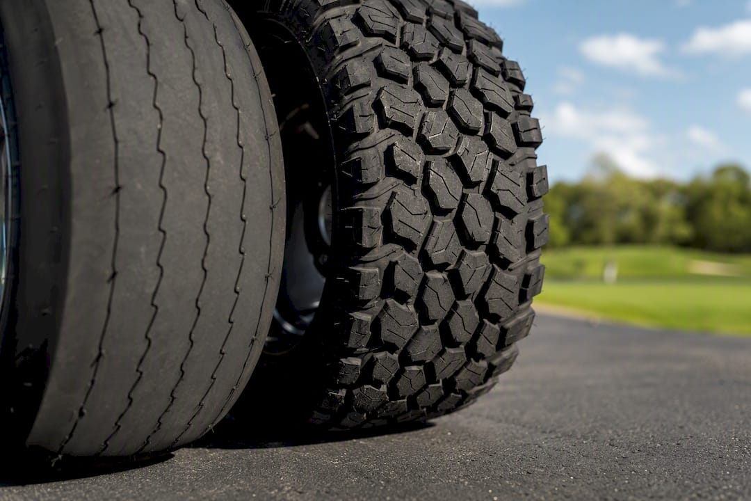 Close-up of two golf cart tires with different treads