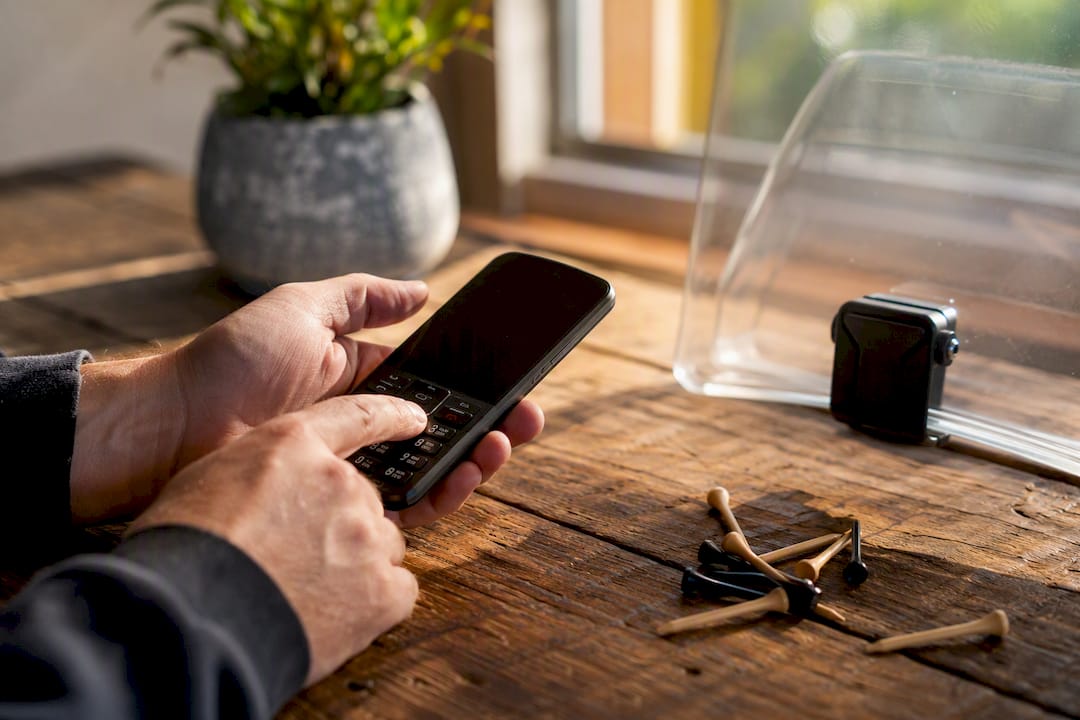 Hands dialing phone to call supplier