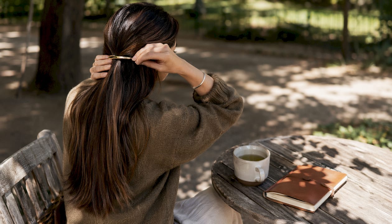 Hands clipping barrette in fine hair at cafΓ©