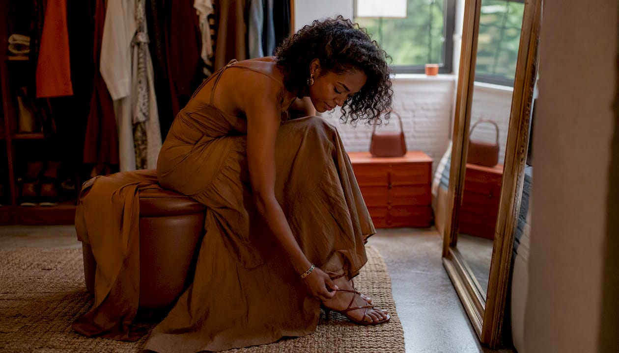 Woman adjusting strappy sandals with outfit