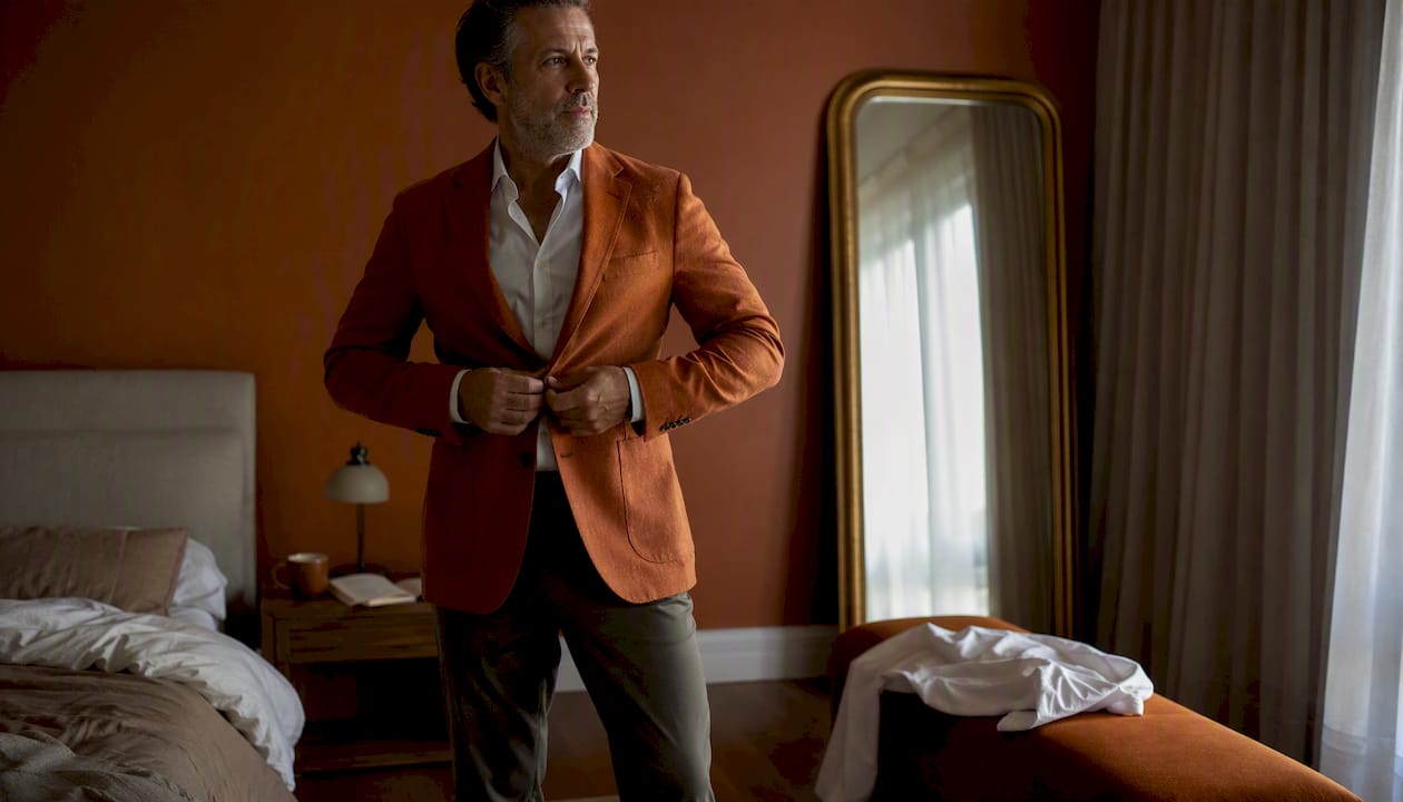 Man putting on structured blazer indoors