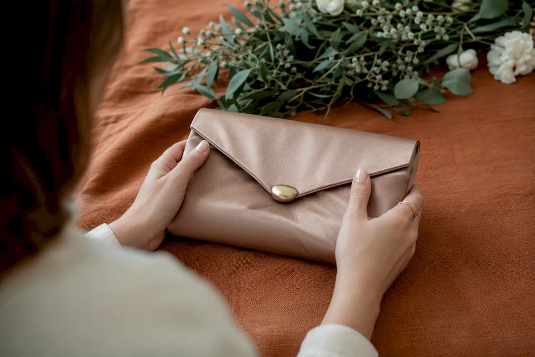 Close-up satin envelope clutch in hands