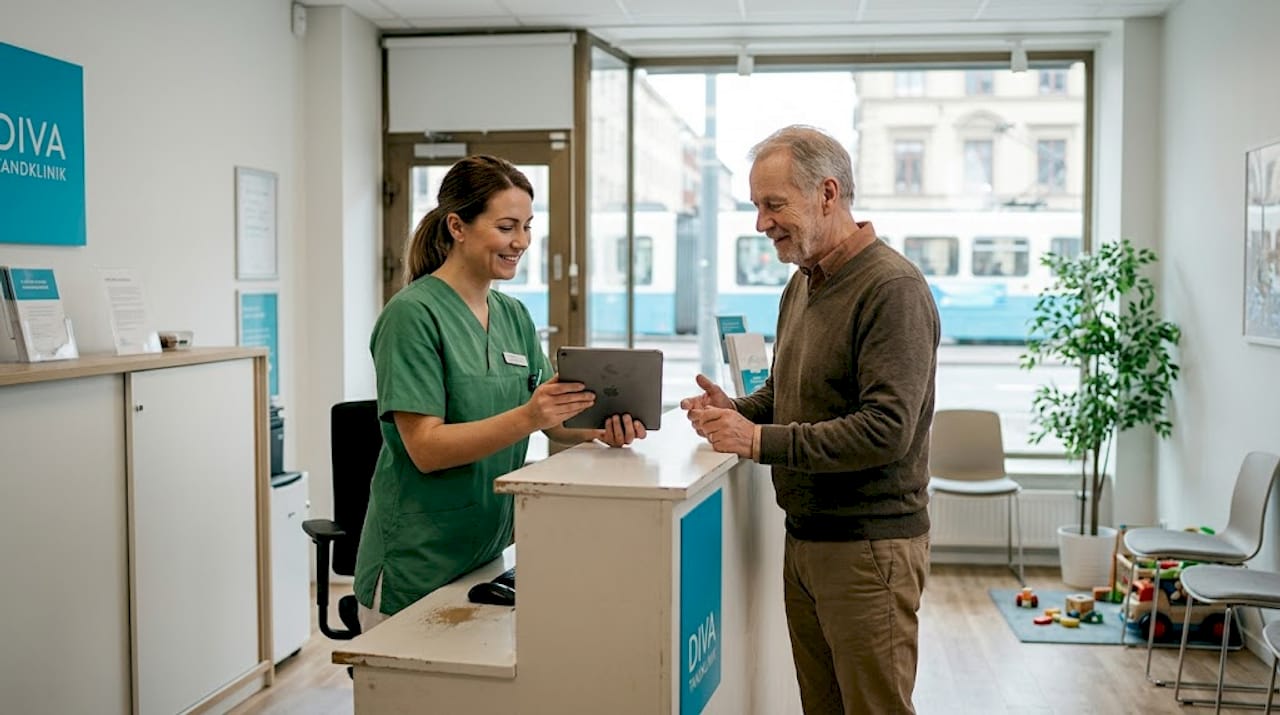 En tandsköterska tar emot en patient i väntrummet och hälsar välkommen till kliniken.