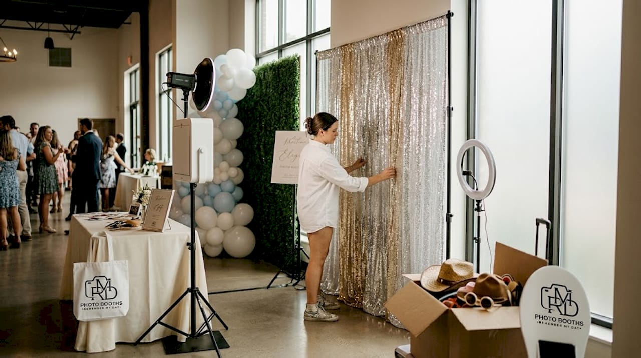 Assistant adjusting wedding photo booth backdrop