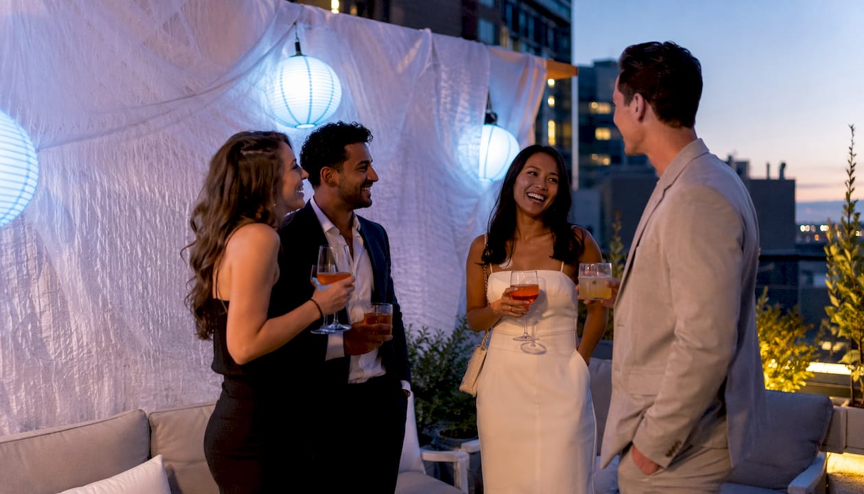 Guests chatting near fabric backdrop