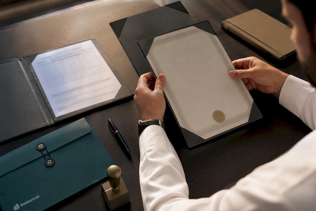 Hands verifying an Umrah completion certificate