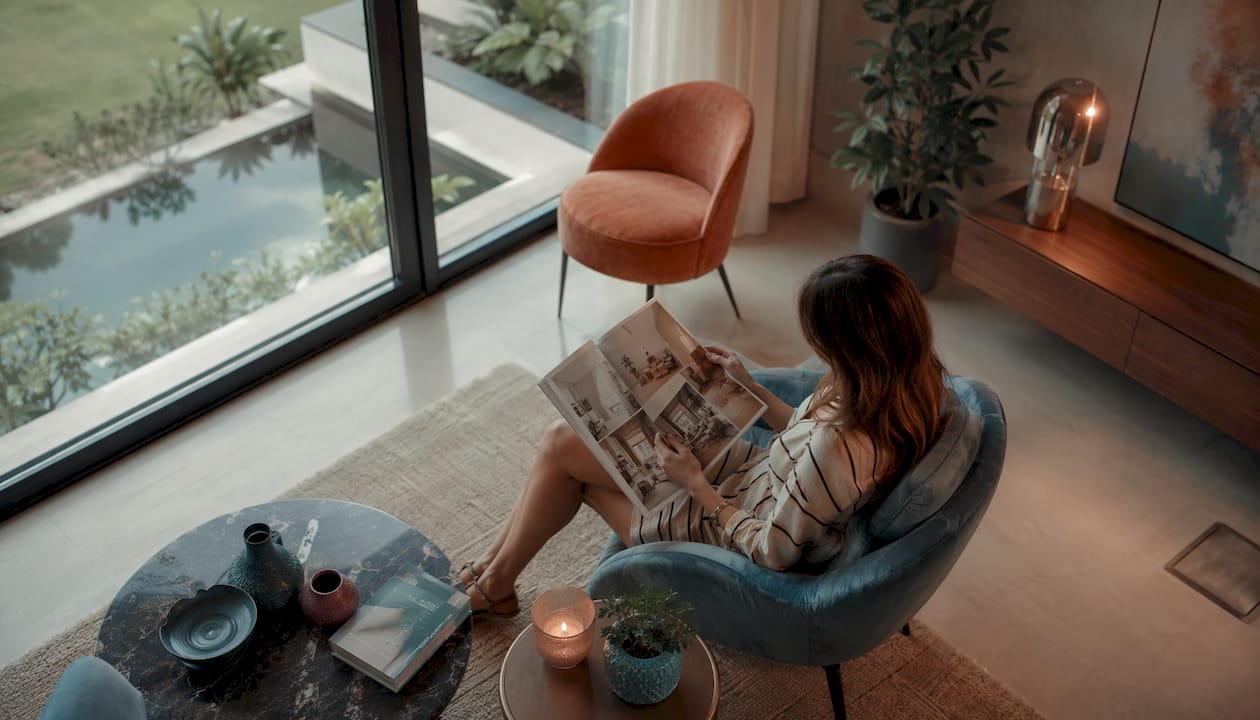 Ambiente elegante y lleno de luz en una exclusiva vivienda, con una mujer disfrutando del espacio.