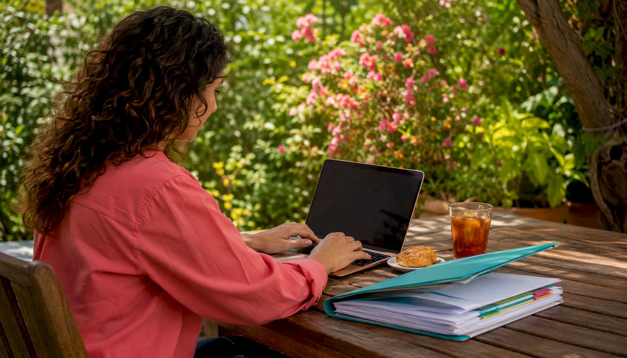 Woman typing license classifications on laptop in co-working space