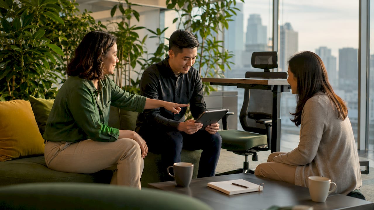 Office workers discussing ergonomic benefits in meeting room