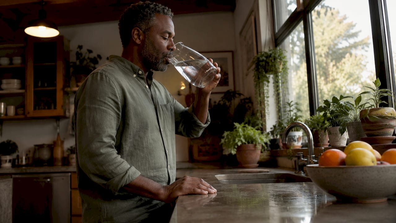 Man testing water in wellness kitchen setting