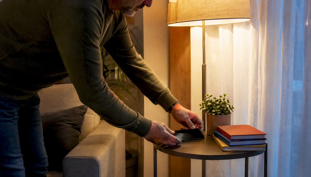 Hands turning off phone before sleep in bedroom