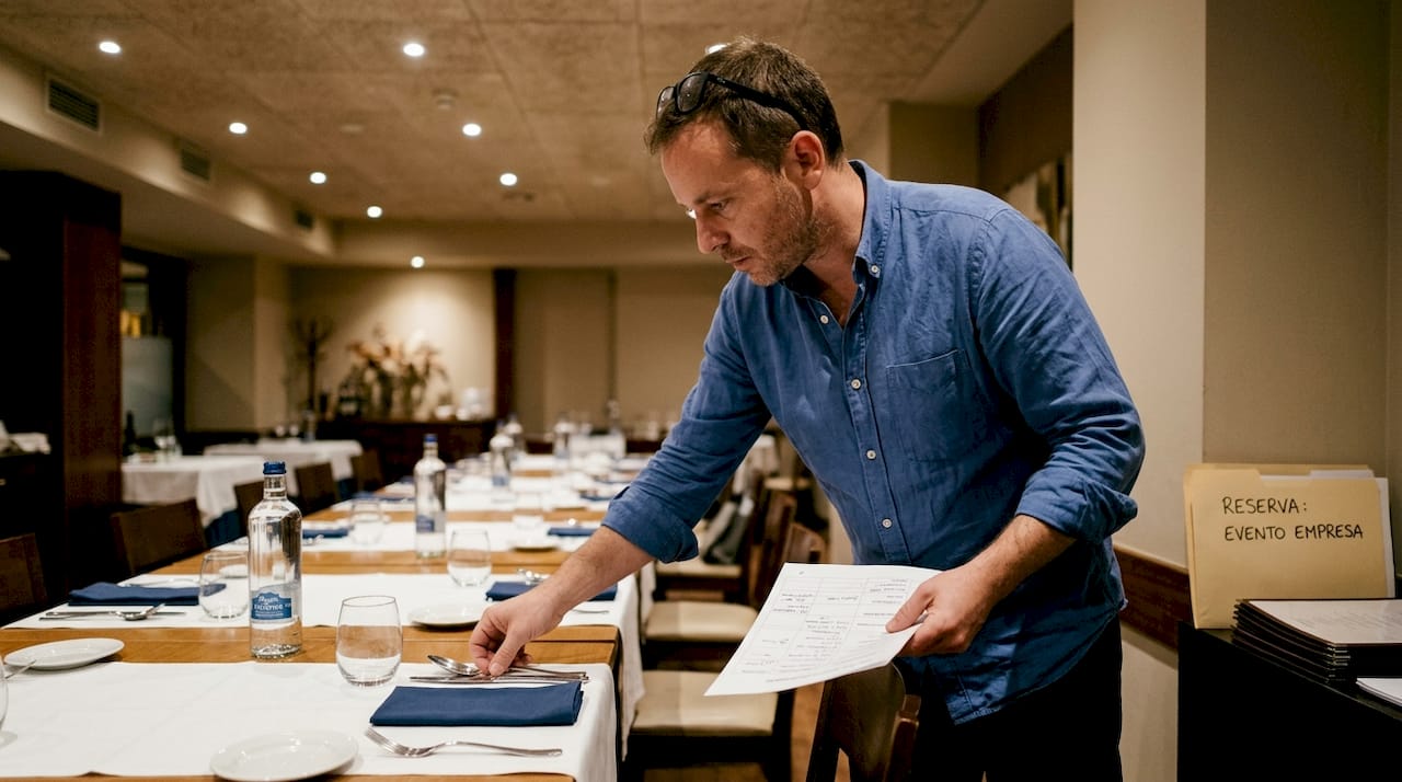 El organizador está preparando la mesa en una sala reservada.