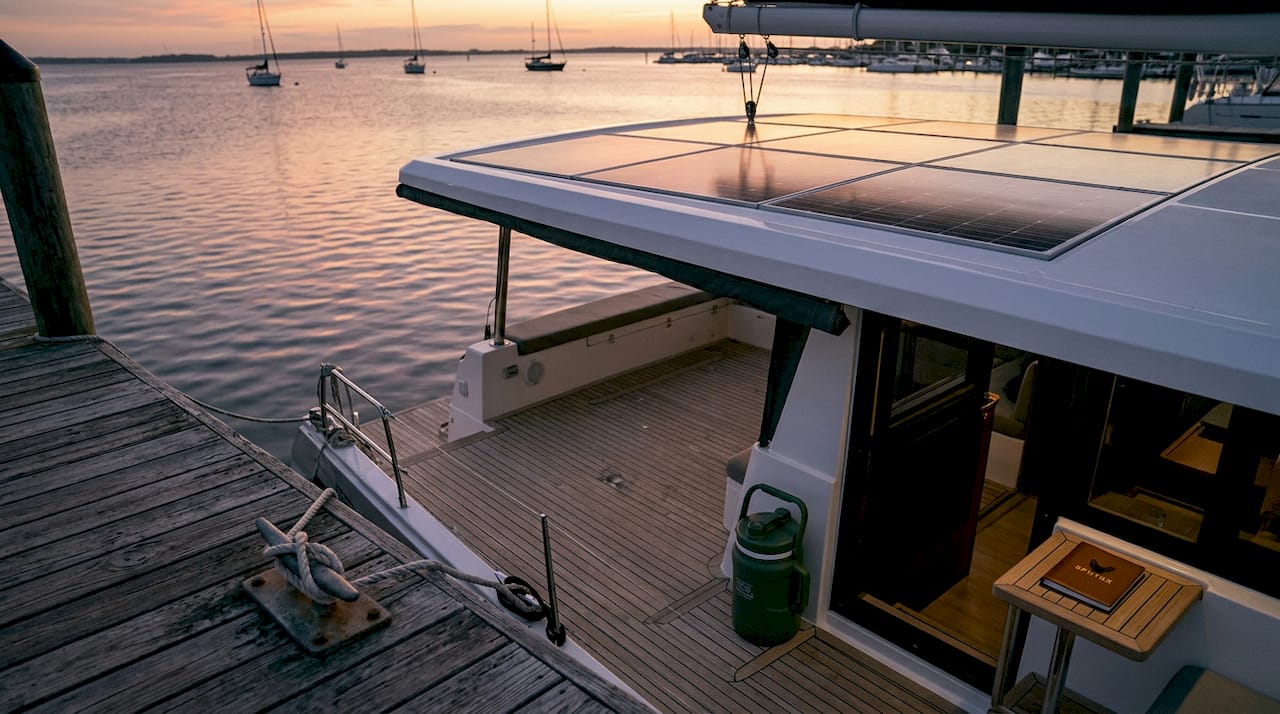 Hybrid yacht with visible solar panels docked