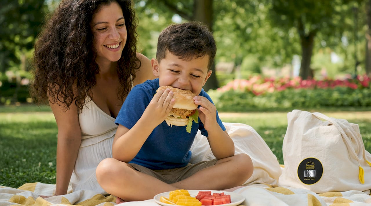 Una madre y su hijo comparten un agradable momento en el restaurante, mientras el pequeño disfruta de un menú infantil lleno de opciones atractivas.
