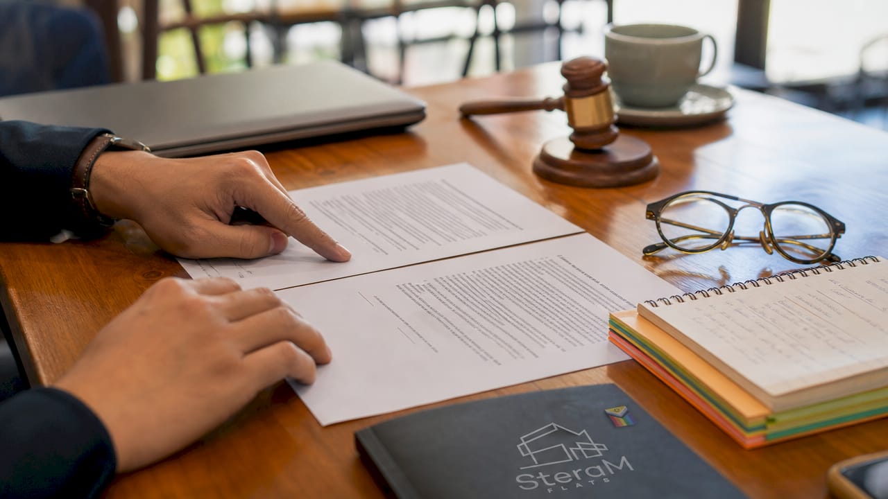 Overhead view of hands comparing tenancy contracts