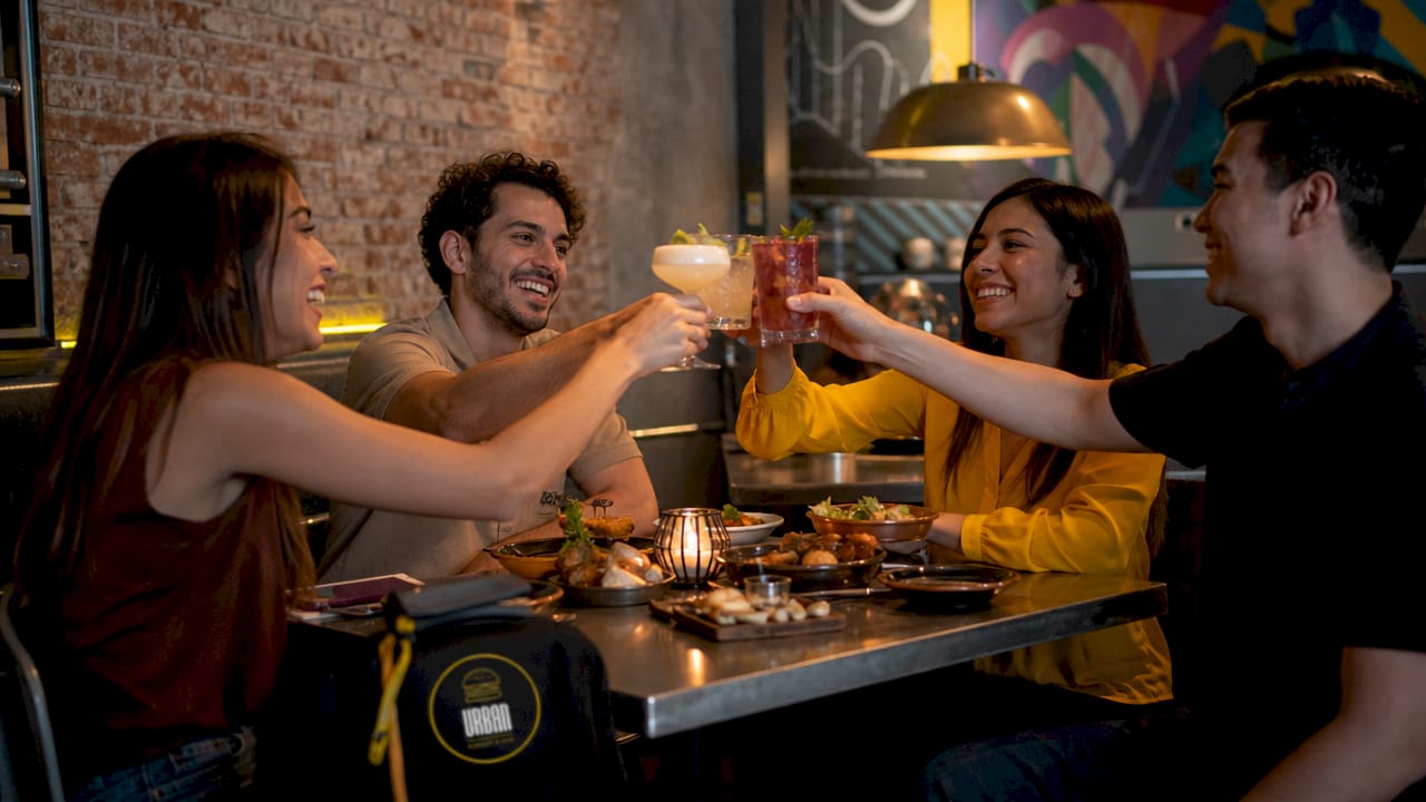 Un grupo de amigos disfruta de una agradable velada en un restaurante moderno con una decoración urbana y actual.