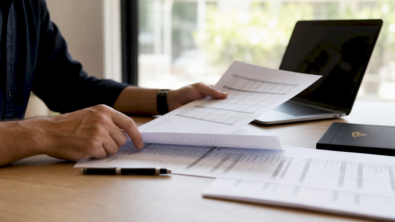 Personas revisando papeles con información empresarial