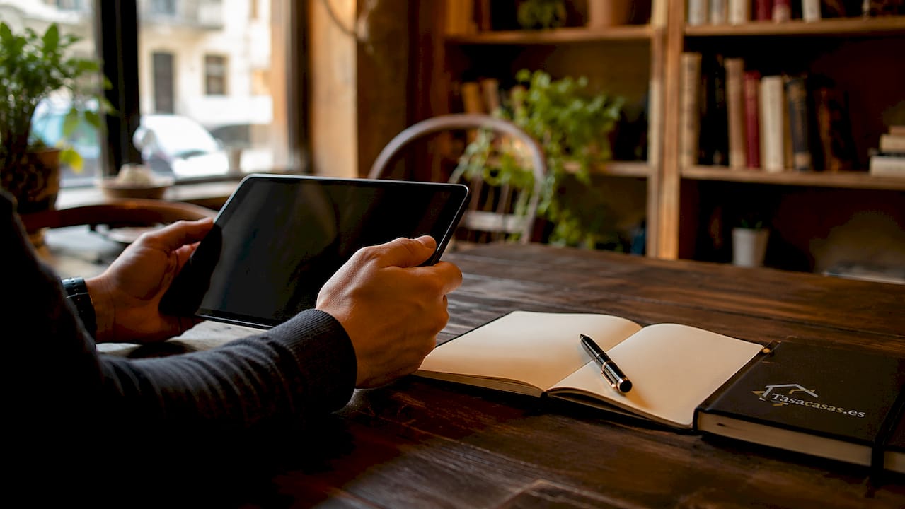 Manos utilizando una tablet durante la tasación de una propiedad