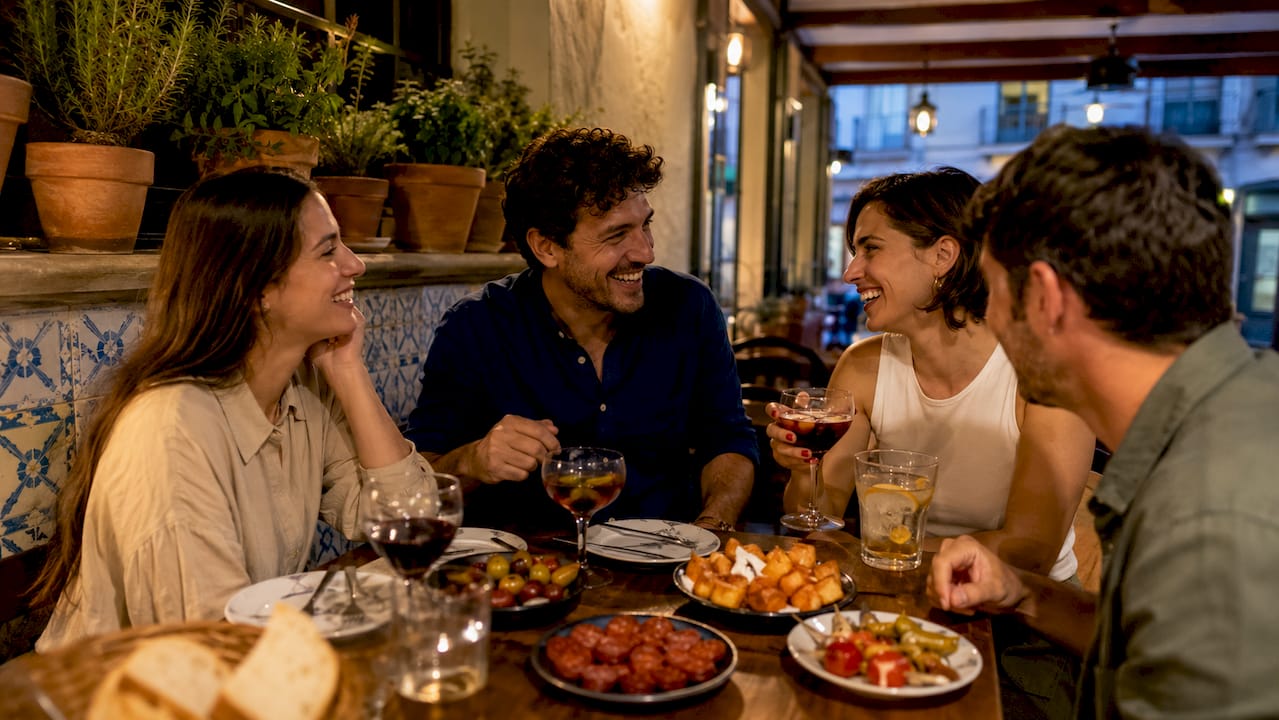 Locals sharing tapas in cozy Spanish bar
