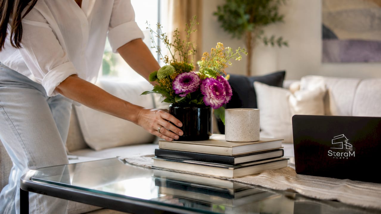 Hands arranging home staging decor on table