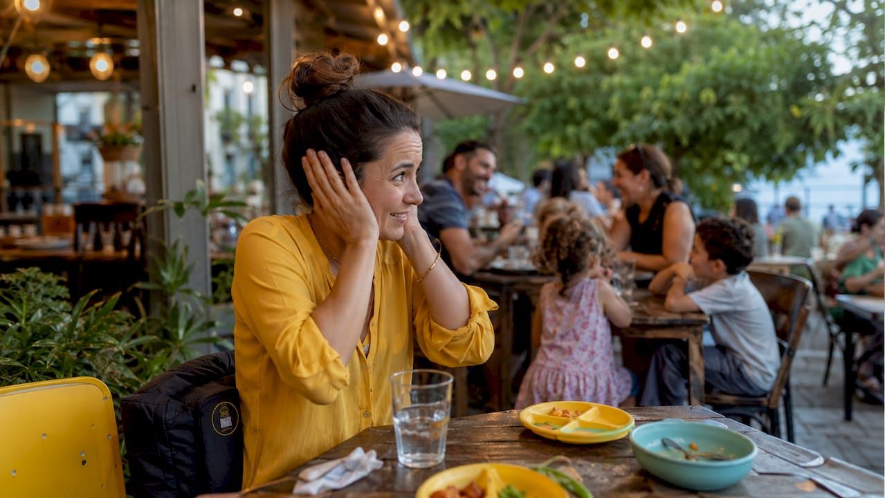 Mujer comprobando el nivel de ruido en un restaurante para familias