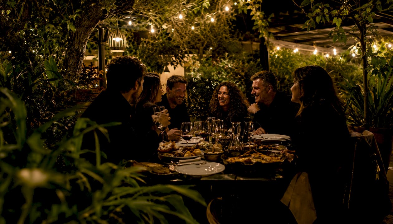 Celebración de cumpleaños en un restaurante con jardín, grupo de amigos disfrutando juntos.
