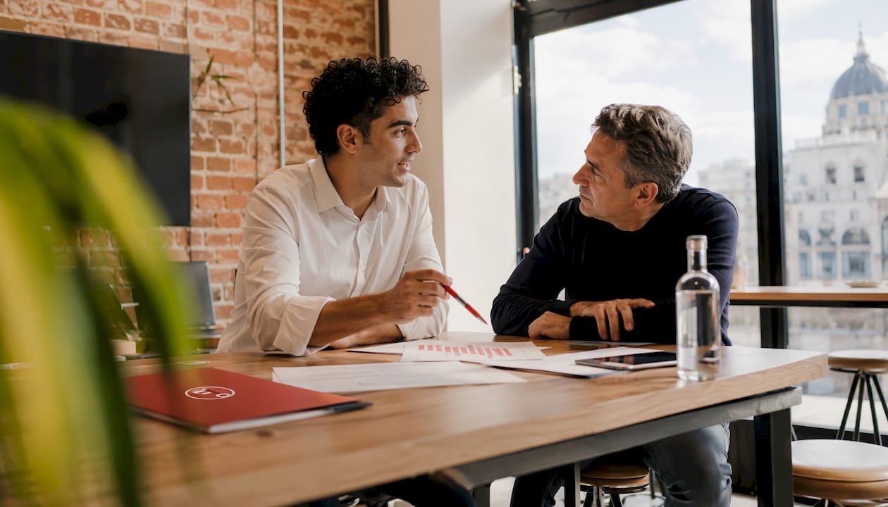 Asesor inmobiliario atendiendo a clientes en la oficina