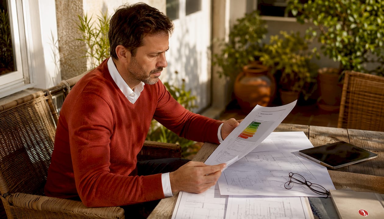 Un técnico revisando y firmando un certificado de eficiencia energética en su despacho