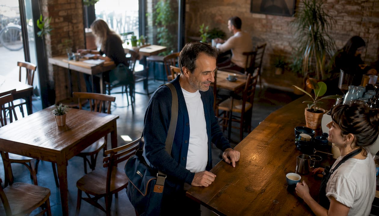 Man ordering coffee at Gràcia plaza café