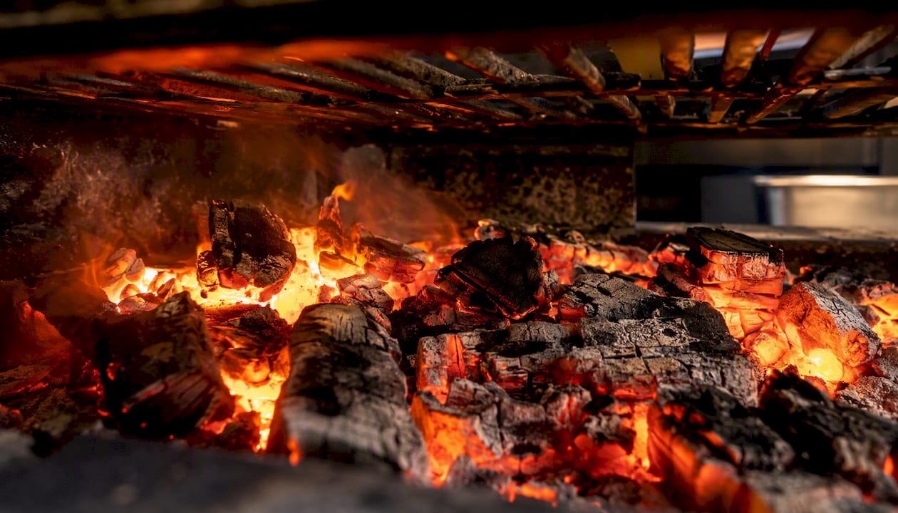 Brasas encendidas bajo la parrilla
