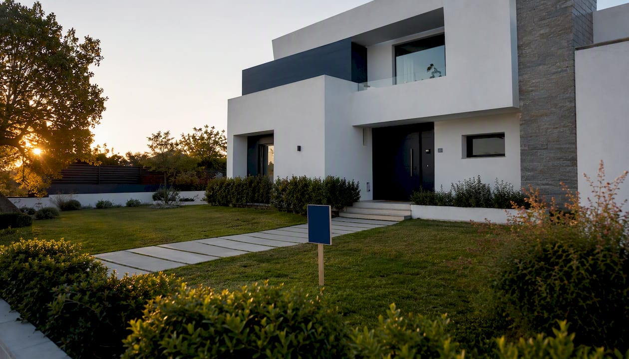 Fachada de una vivienda con cartel de tasación inmobiliaria