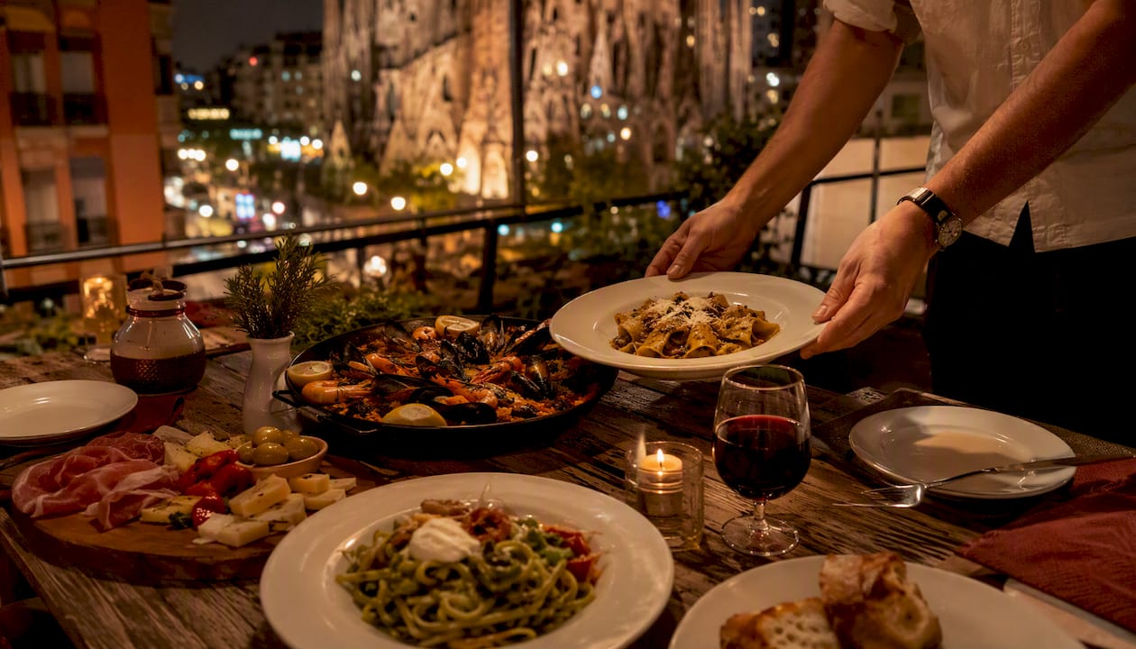 Mesa preparada para una cena mediterránea al aire libre, iluminada por la noche.