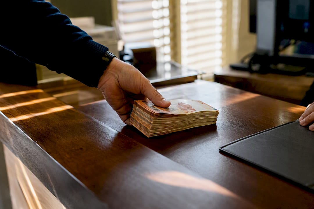 Hand placing euros cash on bank counter