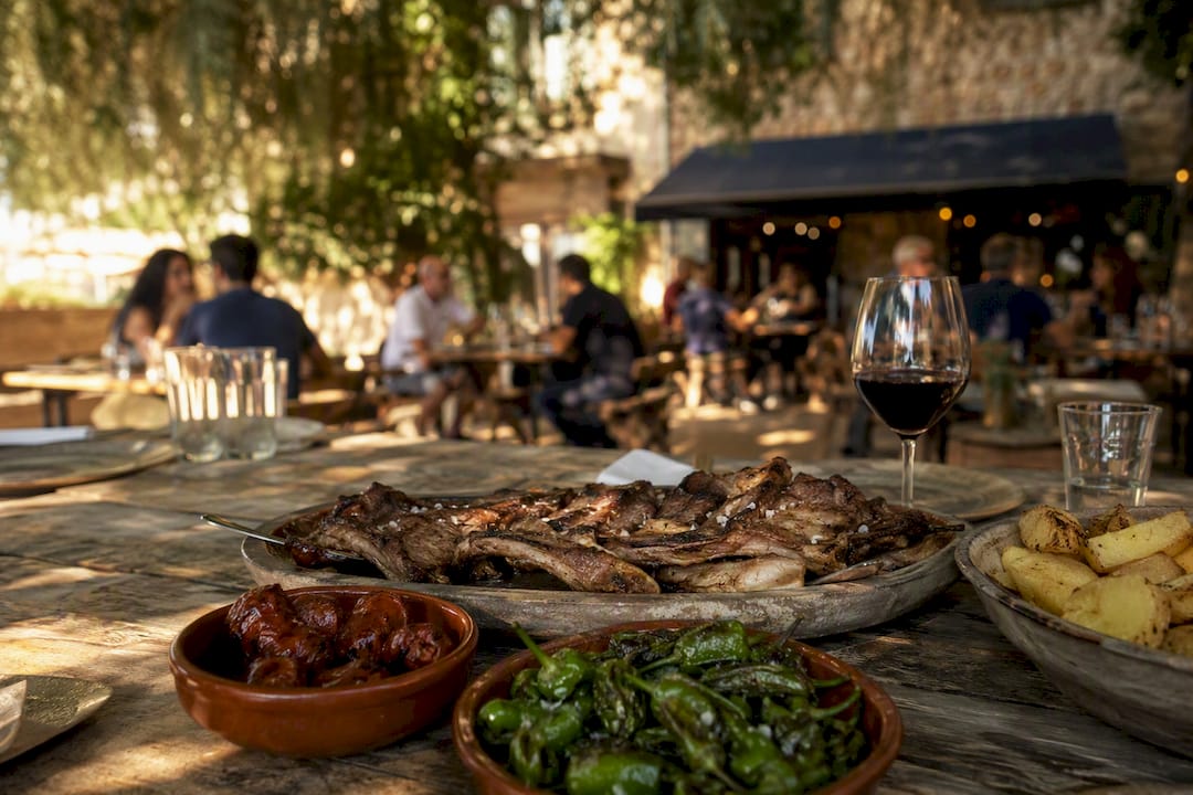 Churrasco gallego servido con guarniciones tradicionales en una mesa de restaurante al aire libre