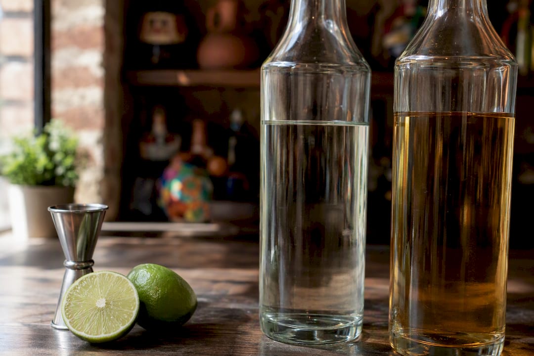 Tequila blanco y reposado en barra de madera rústica