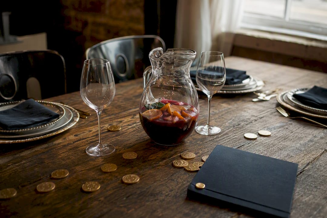 Jarra de sangría con menú y monedas sobre la mesa