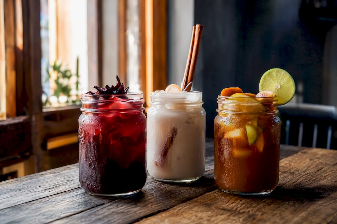 Variedad de bebidas veganas mexicanas sobre una mesa rústica
