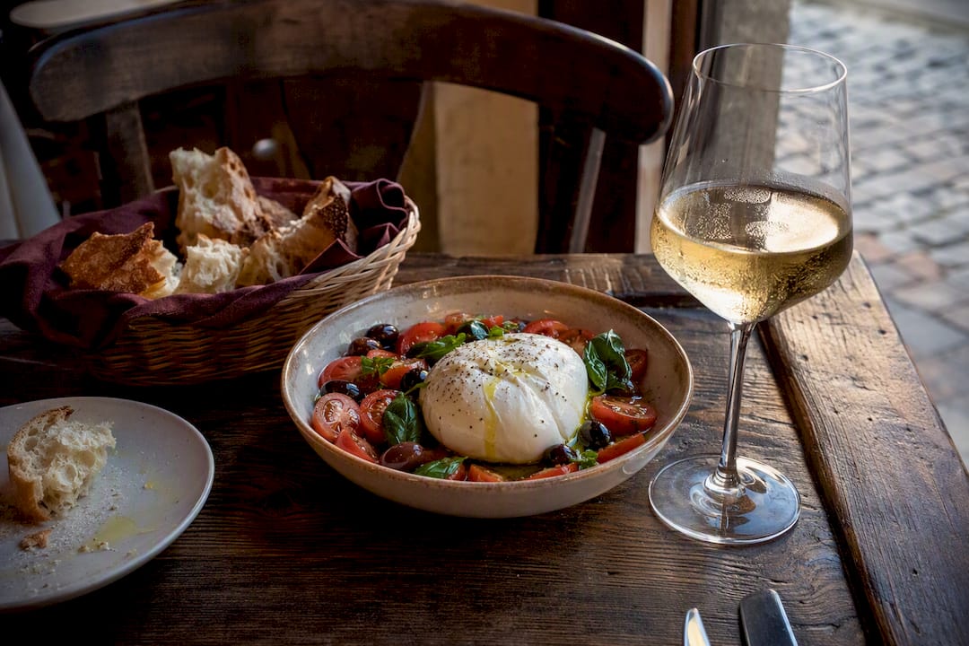 Queso burrata servido con vino y acompañamientos